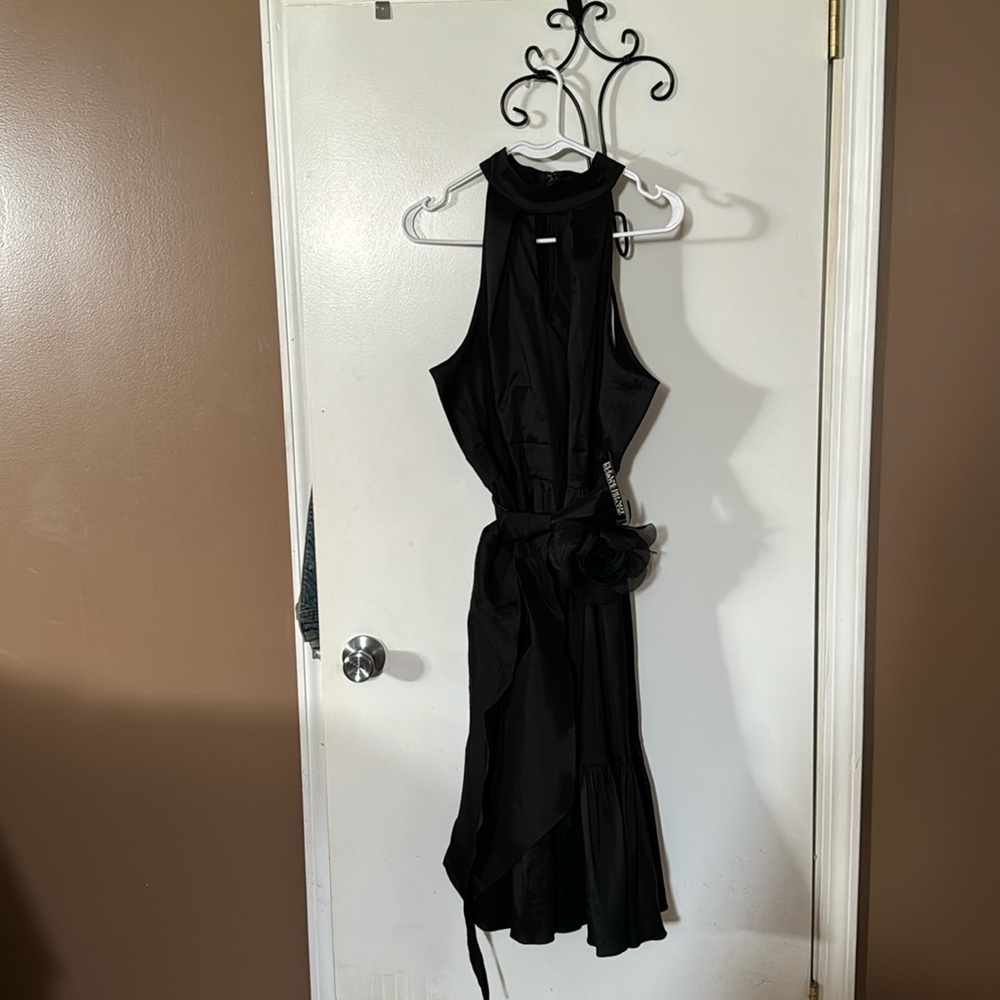 Black sleeveless dress with ruffle at the bottom.